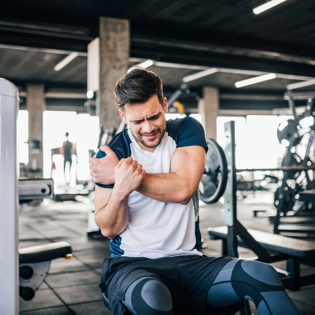 Sportif en salle de sport avec douleur &agrave; l'&eacute;paule